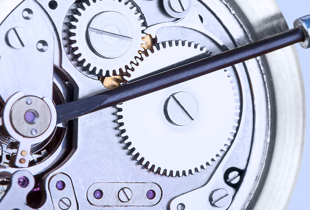 Horlogemaker repareert uurwerk van Breitling horloge met pincet.