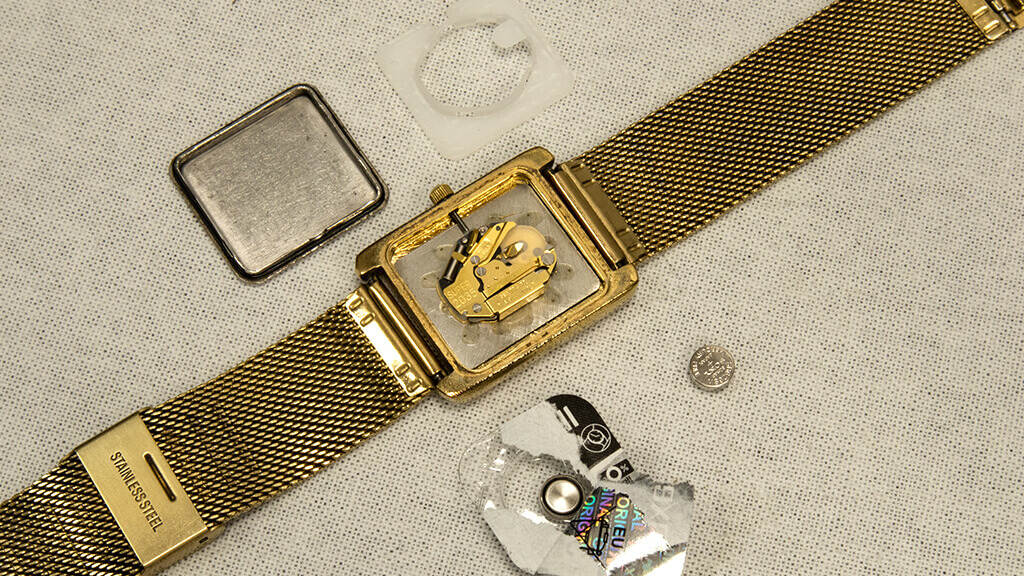 Uurwerk van Christian Dior horloge met losse batterijen ernaast om batterij van Christian Dior horloge te vervangen.