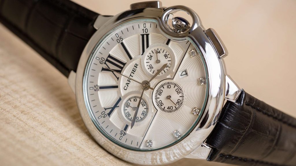 Klassiek Cartier horloge met stalen kast, witte wijzerplaat en een zwart, leren band.