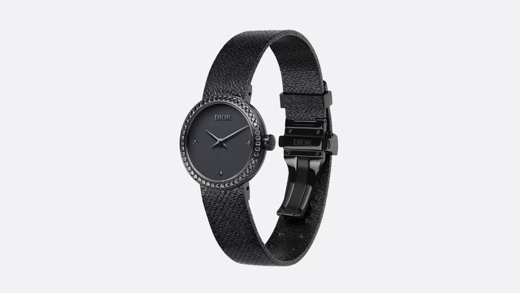 LA D DE DIOR BLACK ULTRAMATTE horloge, 34 mm kast, zwart ultramat staal en zwarte diamanten schuin zijaanzicht op licht grijze, effen achtergrond.