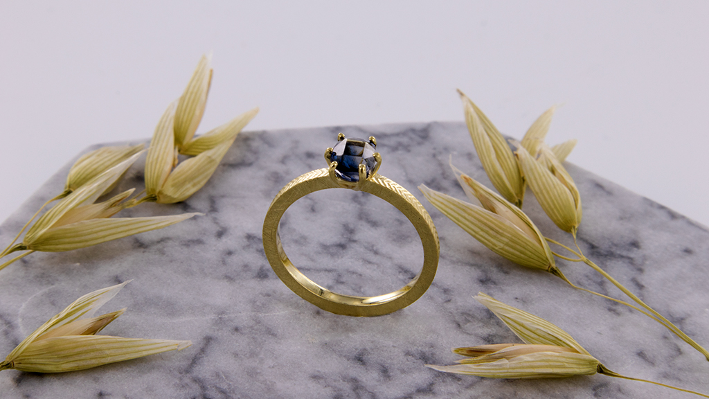 Geelgouden ring van 14 karaat goud met blauwe watersaffier in solitair zetting.