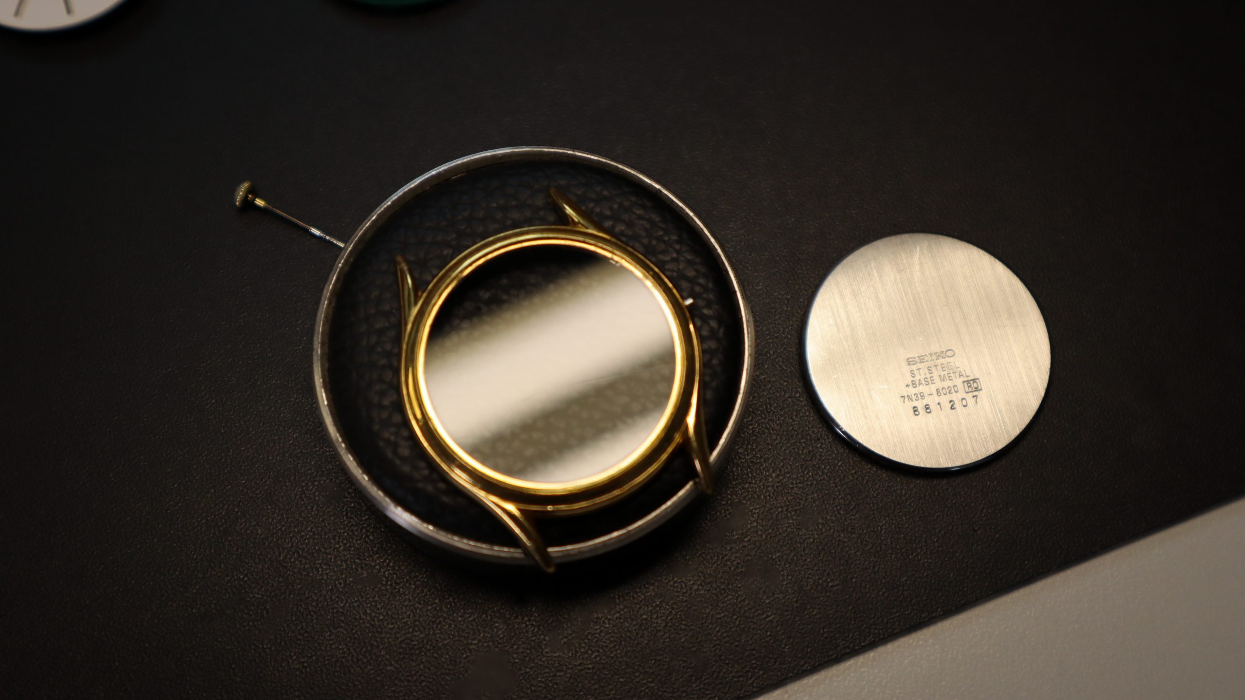 Een horloge glas die zonder uurwerk ligt.