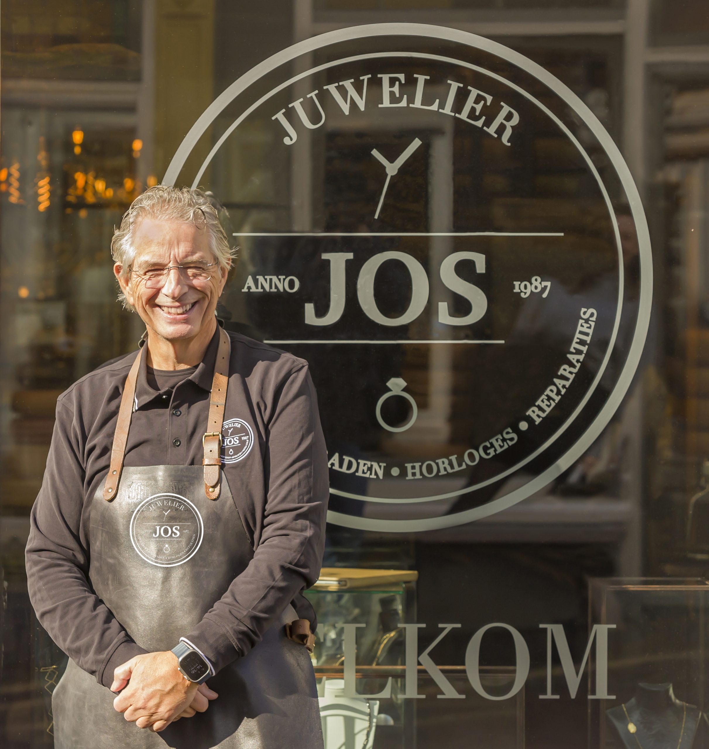 Goudsmid Jos van Beek voor winkel Juwelier Jos met logo op raam.