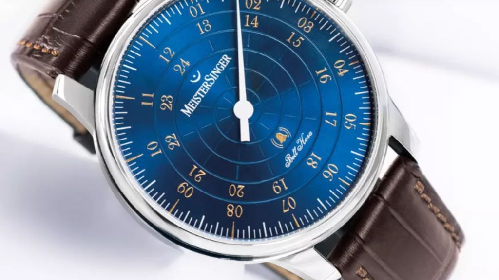Meister Singer horloge met bruin leren band, stalen kast en blauwe wijzerplaat met veel details.