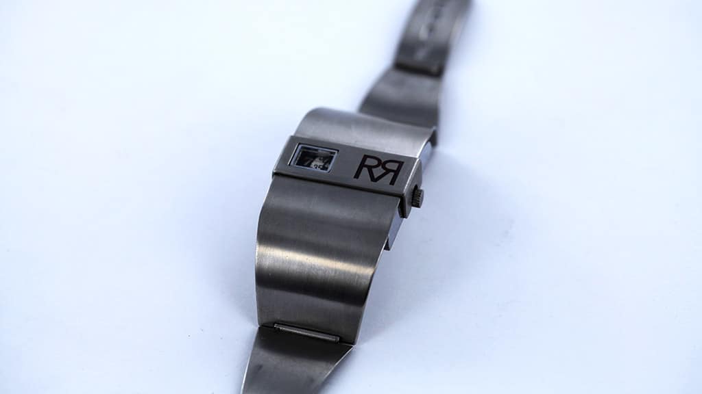 Stalen horloge met stalen horlogeband en lasergravure op de kast van een logo met letters.