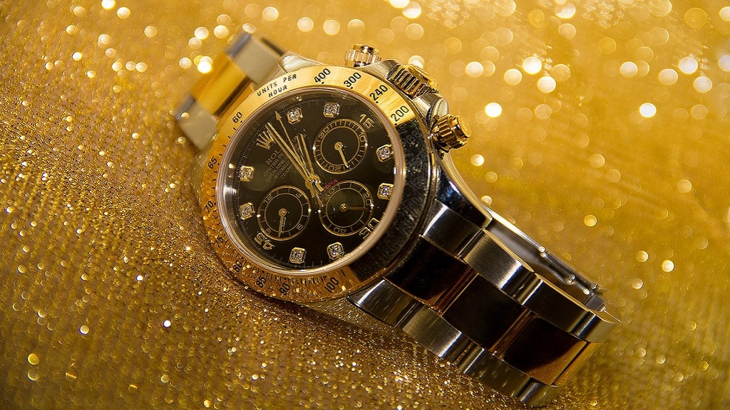 Stalen rolex horloge met gouden accenten en glitters.