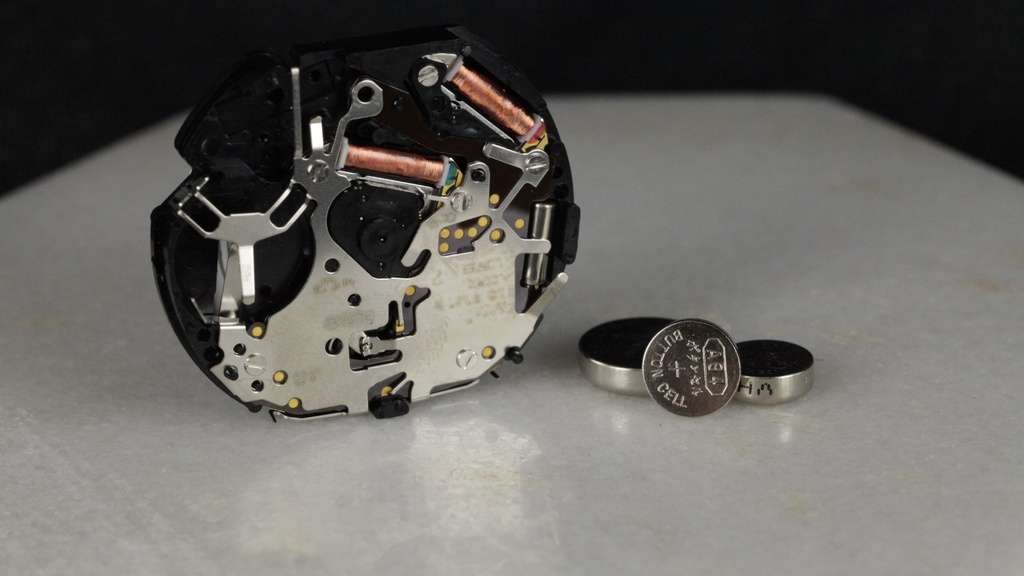 Uurwerk van Christian Dior horloge met losse batterijen ernaast om batterij van Christian Dior horloge te vervangen.