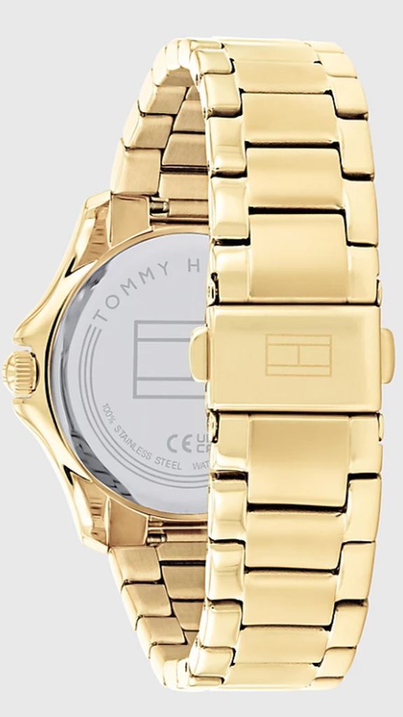 Achteraanzicht van goudkleurig Tommy Hilfiger horloge met goudkleurige kast en band en staalkleurige achterplaat. Horloge op lichtgrijze achtergrond.