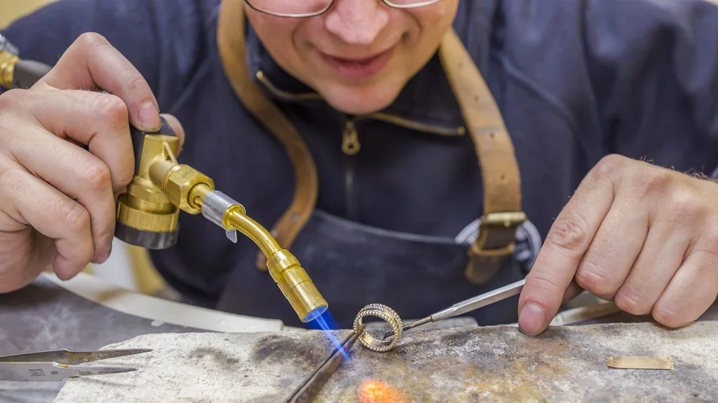 Sieraden reparaties bij Juwelier Jos door Peter achter werkbank die een ring soldeert