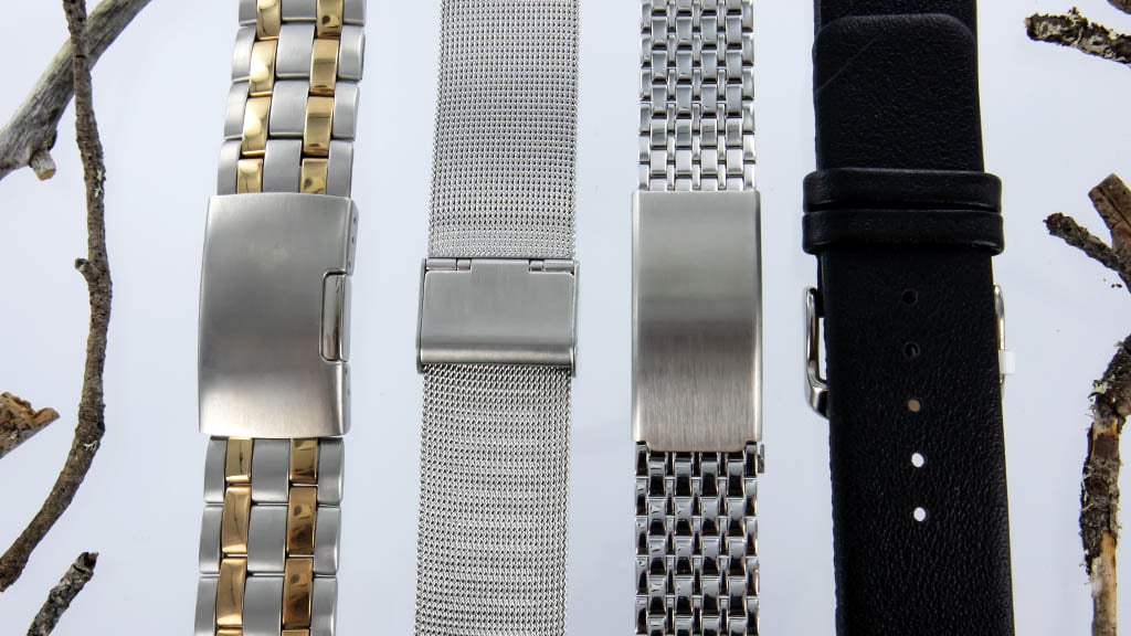 Verschillende stalen horlogebanden, waaronder een zilverkleurige milanese horlogeband en een leren horlogeband.