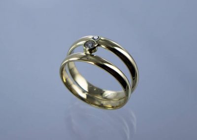 Trouwringen samengevoegd tot 1 ring met open ruimte in midden en briljant geslepen diamant